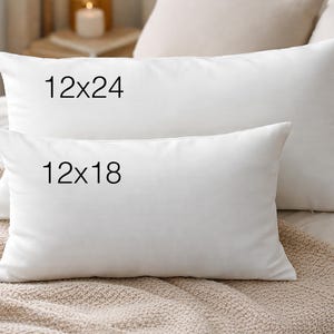 two white pillows on a bed, with the larger pillow labeled "12x24" and the smaller pillow labeled "12x18".