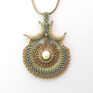 May include: A silver chain necklace with a large, intricate pendant made of beads in shades of gold, silver, and green. The pendant features a central pearl and a design resembling a stylized flower.