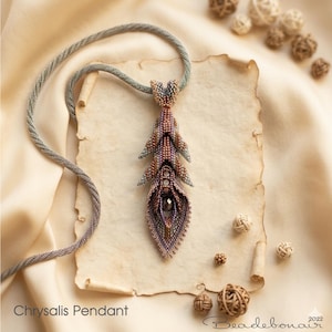 May include: A handcrafted beaded pendant necklace with a chrysalis design. The pendant is made of purple, brown, and grey beads, with a dark gem at its centre. The necklace cord is grey. The text "Chrysalis Pendant" is visible.