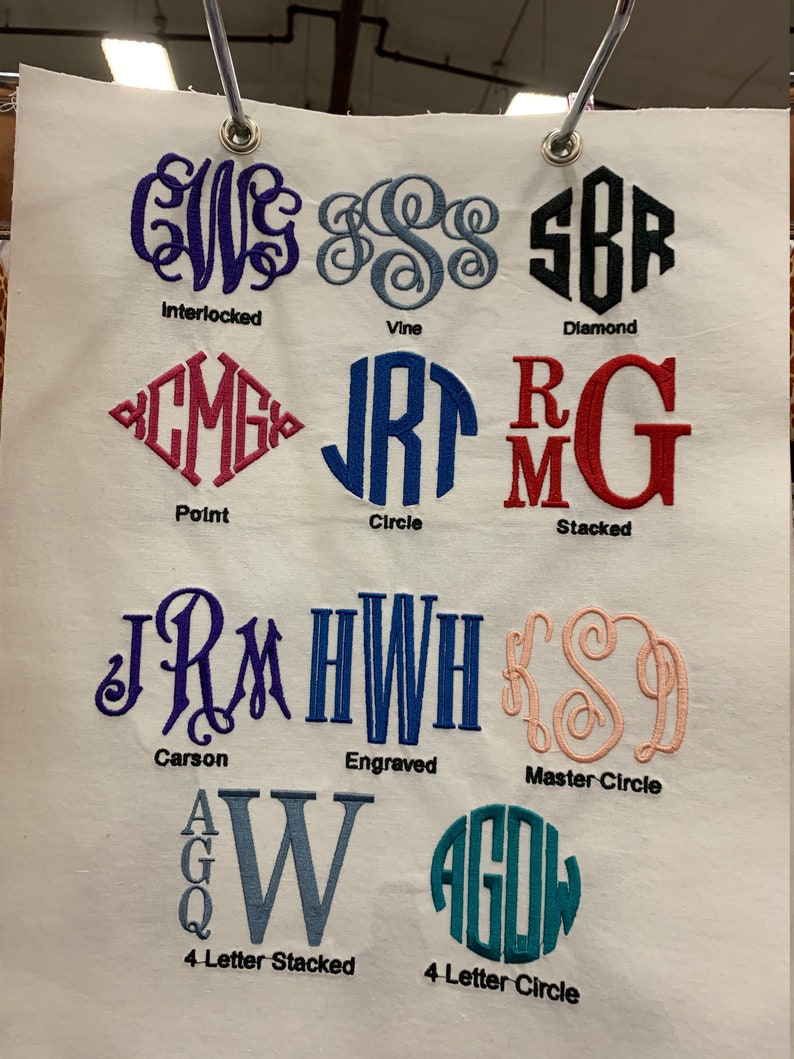 May include: A white fabric swatch with different monogram styles embroidered on it. The styles include Interlocked, Point, Vine, Circle, Diamond, Stacked, Carson, Engraved, Master Circle, 4 Letter Stacked, and 4 Letter Circle.