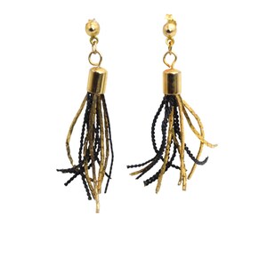 May include: A pair of gold-tone tassel earrings. Each earring features a gold-colored stud and a cylindrical gold-tone cap from which black and gold strands cascade. The earrings are set against a white background.