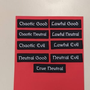 May include: Nine black rectangular patches with white text on a red background. The patches are labeled with the alignment terms "Chaotic Good", "Lawful Good", "Chaotic Neutral", "Lawful Neutral", "Chaotic Evil", "Lawful Evil", "Neutral Good", "Neutral Evil", and "True Neutral".