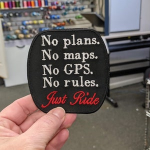 May include: Black embroidered patch with white text that reads "No plans. No maps. No GPS. No rules. Just Ride" in a red cursive font.
