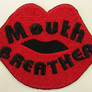 May include: Red embroidered patch shaped like a pair of lips with the text "Mouth Breather" in black.