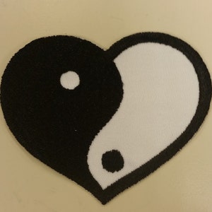 May include: A black and white yin yang symbol in the shape of a heart. The yin yang symbol is a traditional Chinese symbol representing duality and balance.