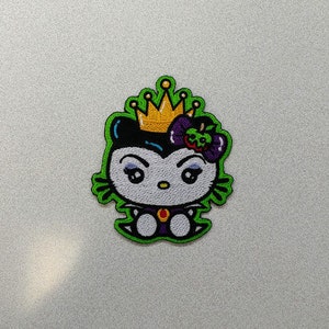 May include: Green embroidered patch of a cartoon character with a crown, black hair, purple flower, and white eyes. The character is wearing a purple dress and has a white collar.