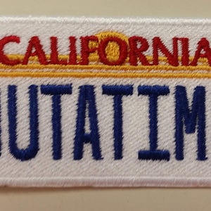 May include: White embroidered patch with a yellow, red, and orange "CALIFORNIA" text and a blue "OUTATIME" text.