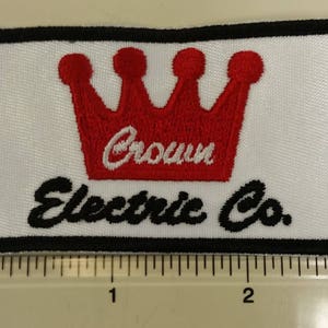 May include: A white embroidered patch with a red crown and the text "Crown Electric Co."