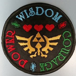 May include: A black circular embroidered patch with a gold Triforce symbol in the center. The words "Wisdom", "Power", "Courage", and "Love" are embroidered around the symbol in different colors.