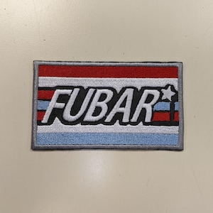 May include: A white, red, and blue striped patch with the word "FUBAR" in black lettering and a white star.