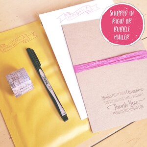 May include: A yellow mailing envelope with a red stamp that says "Kindly Deliver To". A black Sharpie pen and a roll of patterned washi tape are on the envelope. A brown card with the text "You're pretty darn awesome for supporting small business. Thank you. Inanutshellstudio.com" is on top of the envelope. A pink ribbon is on the card. A pink circle with the text "Shipped in rigid or bubble mailer" is in the top right corner of the image.