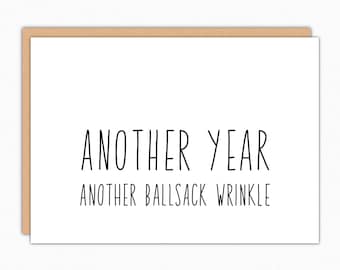 May include: A white card with black text that reads "Another year, another ballsack wrinkle".