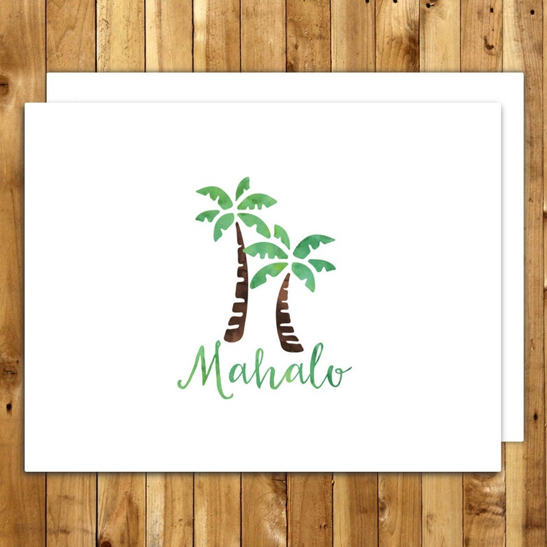 May include: White greeting card featuring two watercolor palm trees in green and brown, with the word "Mahalo" in green script below. The card is set against a wooden background.