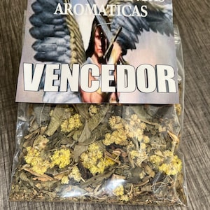 May include: A clear plastic bag filled with dried herbs and flowers. The bag has a label that reads "Baño de Plantas Aromaticas Vencedor" with an image of an angel holding a sword.