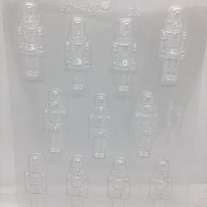 May include: Clear plastic mold with ten cavities in the shape of toy soldiers. The mold has the number "90-4029" printed on the top left. The cavities are arranged in three rows, with the soldiers facing forward.
