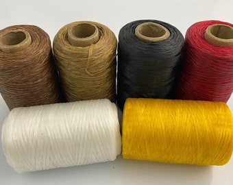 May include: Six spools of thread in various colors, including brown, tan, black, red, white, and yellow. The spools are arranged in a row, with the brown spool at the left and the yellow spool at the right.