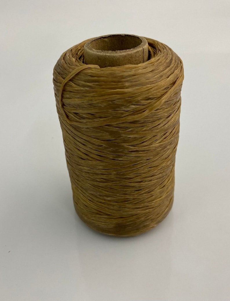 May include: A spool of brown waxed thread wound around a cardboard tube.