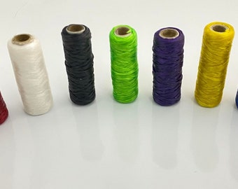 May include: Ten spools of thread in various colors, including brown, red, white, black, green, purple, yellow, blue, and teal.