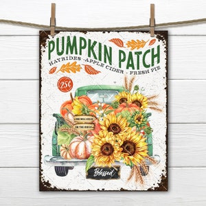 May include: A vintage-style metal sign with a green truck filled with pumpkins and sunflowers. The sign reads "Pumpkin Patch" with the text "Hayrides - Apple Cider - Fresh Pie" and "25c" underneath. The sign also has a small chalkboard that says "Blessed".
