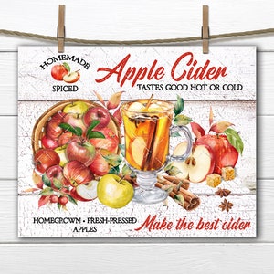 Pode incluir: Uma placa branca com uma faixa vermelha e branca que diz "Homemade Apple Cider Spiced" e "Tastes Good Hot or Cold". A placa também tem uma imagem de um copo de sidra de maçã com paus de canela e uma cesta de maçãs. O texto na parte inferior da placa diz "Homegrown Fresh-Pressed Apples Make the best cider".
