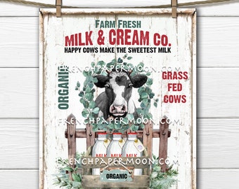 May include: A white sign with red and green text that reads "Farm Fresh Milk & Cream Co. Happy Cows Make The Sweetest Milk". A black and white cow with a green wreath around its head is in the center of the sign. Three glass milk bottles with red lids are in a wooden crate with the word "Organic" on the front. The sign has a distressed white background with a wooden fence and green leaves.