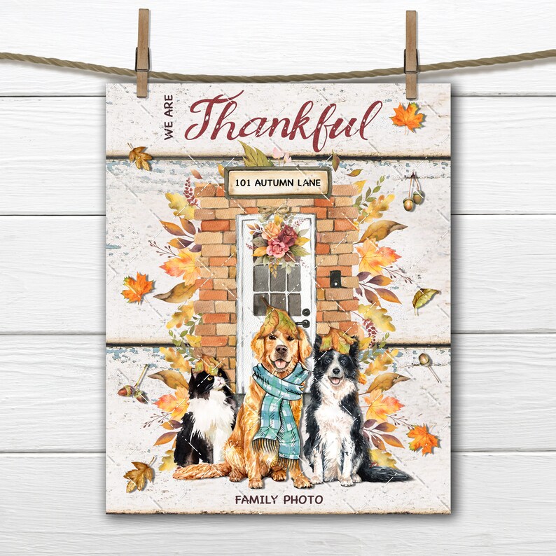 May include: A Thanksgiving-themed print featuring a brick house with a white door and the text "We are Thankful" and "101 Autumn Lane". Three pets, a black cat, a golden retriever wearing a blue scarf, and a black and white border collie, are sitting in front of the house. The text "Family Photo" is at the bottom of the print.