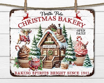 May include: A vintage-style metal sign with a white background and red text. It reads "North Pole Christmas Bakery" with a gingerbread house, reindeer, and cupcakes. The sign also says "Open Daily" and "Baking Spirits Bright Since 1901."