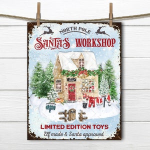 May include: A vintage-style metal sign with a snowy scene of Santa's Workshop. The sign features a small house with a red door and a sign that reads "Santa's Workshop". The text at the bottom reads "Limited Edition Toys Elf made & Santa approved".