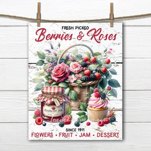 May include: A white wooden sign with the text "FRESH PICKED Berries & Roses" in red lettering. The sign features a basket of red and black berries, a jar of raspberry jam, and a pink cupcake with berries on top. The text "SINCE 1911" and "FLOWERS FRUIT JAM DESSERT" is also on the sign.