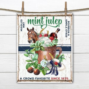 May include: A vintage-style sign with a white background and blue stripes. It features a copper mug filled with ice, mint leaves, and a brown horse head. The text reads "mint julep" in green lettering and "bourbon & simple syrup" in black lettering. The sign also includes the text "A crowd favourite since 1875".