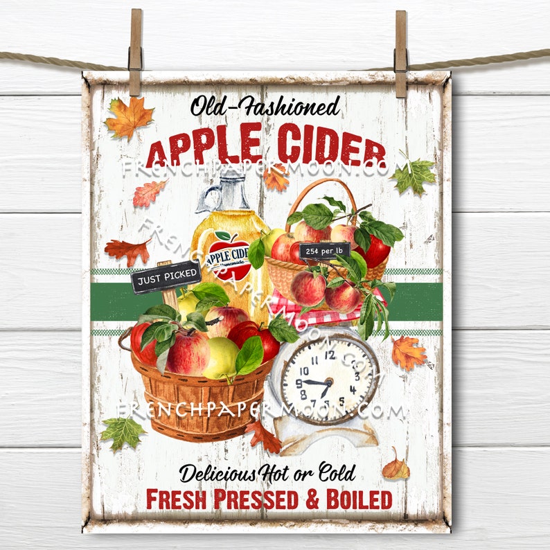 May include: A vintage-style sign advertising old-fashioned apple cider. The sign features a basket of red apples, a glass bottle of apple cider, and a scale with a clock face. The text on the sign reads "Old-Fashioned Apple Cider", "Just Picked", "254 per lb", "Delicious Hot or Cold", and "Fresh Pressed & Boiled".