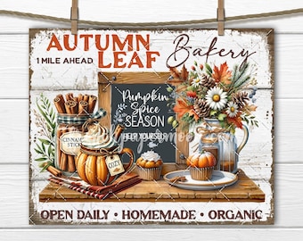 May include: A rustic wooden sign with the words "Autumn Leaf Bakery" and "Pumpkin Spice Season." The image features a pumpkin spice latte, cinnamon sticks, cupcakes, and a bouquet of fall flowers. The sign is decorated with fall-themed elements.