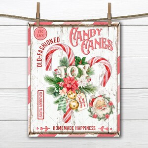 May include: A vintage-style sign with a white background and red and white striped candy canes. The sign says "Candy Canes" in pink lettering and "Old-Fashioned" in black lettering. The sign also has a wreath of holly and berries with the word "JOY" in the center. The sign says "Santa Approved" and "Homemade Happiness" in black lettering.