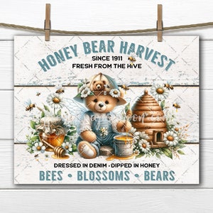 May include: A vintage-style sign featuring a cartoon bear wearing a blue denim outfit and a hat, holding a honey dipper over a bucket of honey. The sign reads "Honey Bear Harvest Since 1911 Fresh From The Hive" and "Dressed in Denim Dipped in Honey Bees Blossoms Bears".