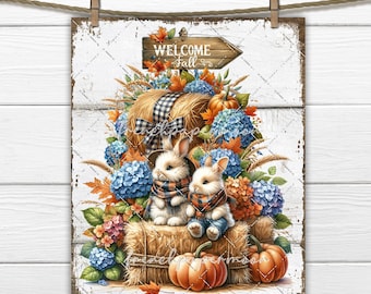 May include: A white wooden sign with a welcome fall sign and two bunnies sitting on a bale of hay with pumpkins and fall flowers.