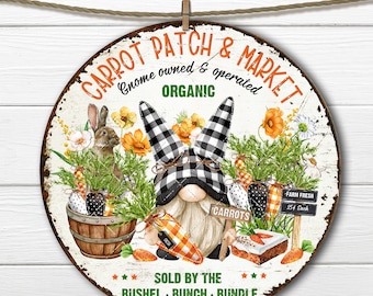 May include: A round, white sign with a rustic, distressed look. It features a gnome with a black and white checkered hat holding carrots. The sign reads "Carrot Patch & Market, Gnome owned & operated, Organic, Carrots, Farm Fresh, 25¢ Each, Sold by the Bushel, Bunch, Bundle".