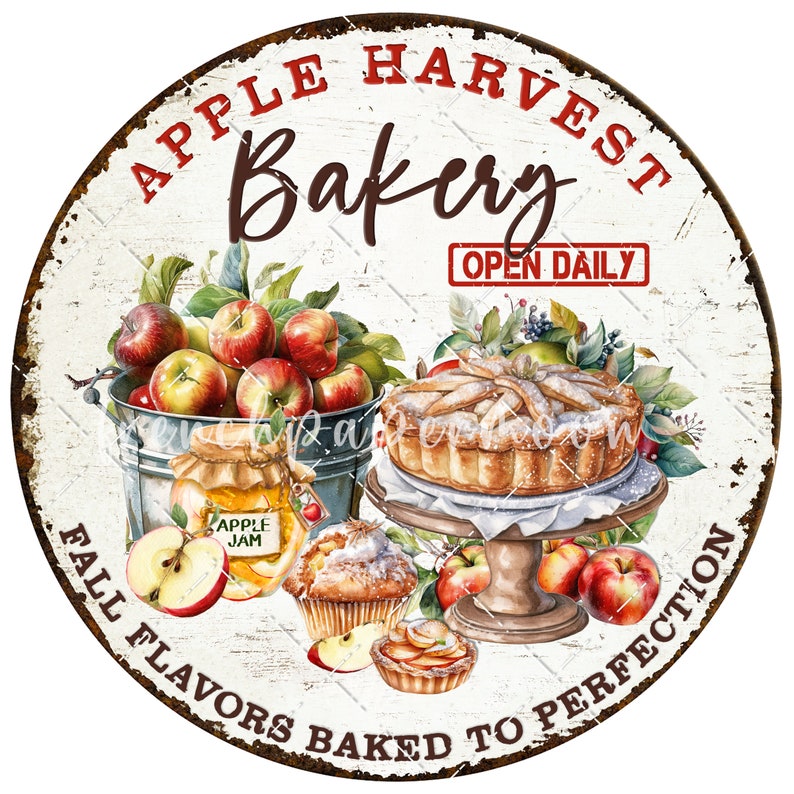 May include: A round, white sign with red and brown text that reads "Apple Harvest Bakery Open Daily Fall Flavors Baked to Perfection". The sign features a watercolor illustration of apples, a pie, and other baked goods.