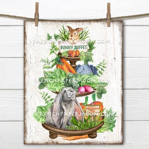 Pode incluir: Uma placa de madeira caiada com um suporte de três níveis decorado com vegetais da primavera, um coelho castanho e um coelho verde. A placa diz "Bunny Buffet".