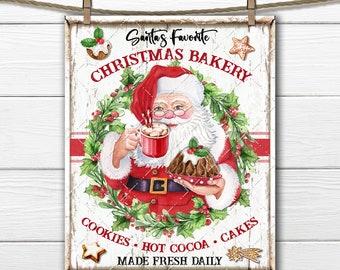 May include: A white sign with red and green accents featuring a cartoon Santa Claus holding a cup of hot cocoa and a plate of Christmas cakes. The sign reads "Santa's Favorite Christmas Bakery Cookies - Hot Cocoa - Cakes Made Fresh Daily".