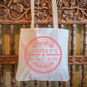 May include: A white canvas tote bag with a red circle logo that says "Hotel Van Zandt, Sep 2019, Lindsey's Bachelorette Weekend, Austin, Texas".