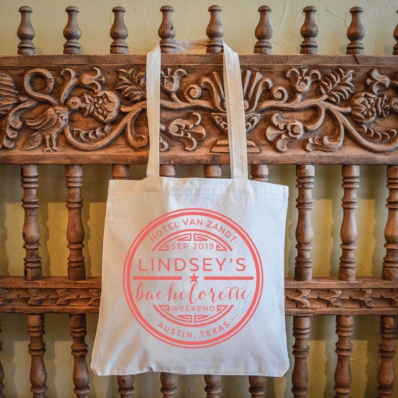 May include: A white canvas tote bag with a red circle logo that says "Hotel Van Zandt, Sep 2019, Lindsey's Bachelorette Weekend, Austin, Texas".