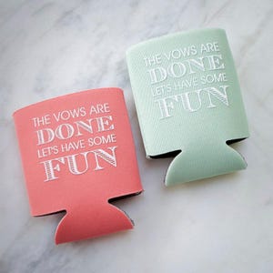 May include: Two foam can coolers, one coral and one mint green, each featuring the white printed text THE VOWS ARE DONE LET'S HAVE SOME FUN. These beverage insulators have a notched base design and are constructed from a flexible, soft material.
