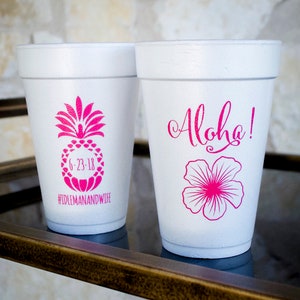 May include: Two white foam cups with pink designs. One cup has a pineapple with the text "6-23-18" and "#IDLEMANANDWIFE". The other cup has a pink hibiscus flower and the text "Aloha!"
