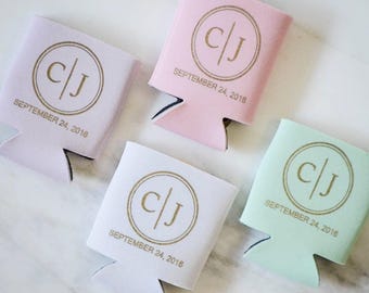 May include: Four foam can coolers in pastel shades of lavender, pink, white, and mint green. Each features a gold circular monogram with the letters C and J separated by a vertical line, and the text SEPTEMBER 24, 2016 printed below.