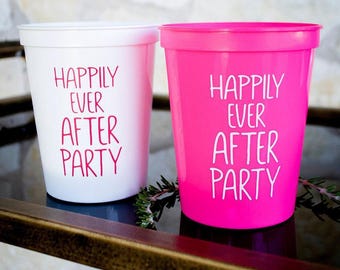 May include: Two plastic stadium cups, one white with pink text and one hot pink with white text. Both cups feature the phrase "HAPPILY EVER AFTER PARTY" printed in a clean, sans-serif font. The cups have a wide rim and a tapered cylindrical shape.