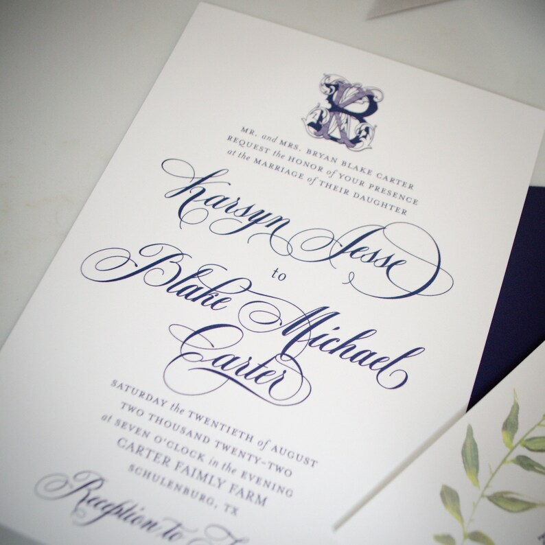 May include: Wedding invitation with a white background and navy blue calligraphy. The invitation reads "Mr. and Mrs. Bryan Blake Carter request the honor of your presence at the marriage of their daughter Karsyn Jesse to Blake Michael Carter Saturday the twentieth of August two thousand twenty-two at seven o'clock in the evening Carter Family Farm Schulenburg, TX Reception to follow"