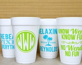 May include: Four white foam cups with printed text and graphics. The first cup says THE BEACH FIXES EVERYTHING in blue. The second has a green circular monogram with WWW. The third says RELAXING WITH THE REYNOLDS with palm trees. The fourth says KNOW WENDY KNOW FUN NO WENDY NO FUN in green.