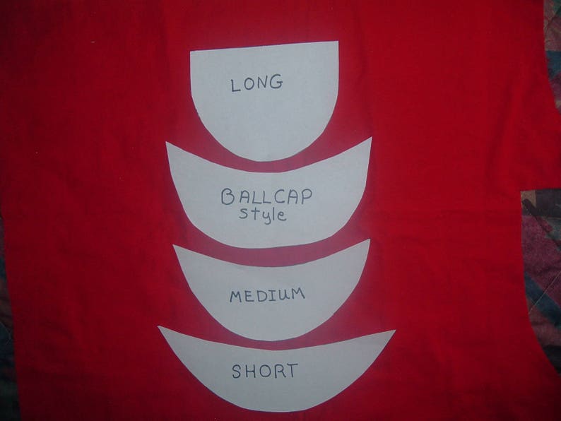 Puede incluir: Fondo de tela roja con cuatro recortes de papel blanco. Los recortes est&aacute;n etiquetados como "LONG", "BALLCAP style", "MEDIUM" y "SHORT". Los recortes est&aacute;n dispuestos verticalmente.
