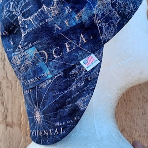 May include: A blue and white map-patterned welding cap with the text "OCEAN" and "MADE IN USA" on the side.