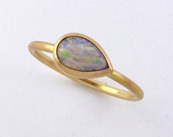 May include: A gold ring with a teardrop-shaped opal gemstone.